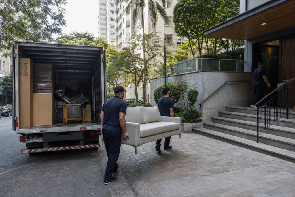 Caminhão de mudança na rua de São Paulo com acesso a edifício residencial